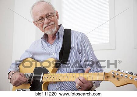 Stock Image - Caucasian man playing electric guitar. Fotosearch