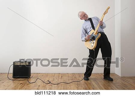 Stock Photo - Caucasian man playing electric guitar. Fotosearch