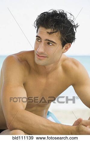 Stock Photo - Caucasian man sitting outdoors. Fotosearch