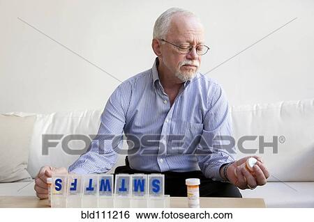 Stock Photograph - Caucasian man taking pills. Fotosearch