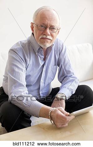 Caucasian man using tablet computer on sofa View Large Photo Image Stock Image - Caucasian man using tablet computer on sofa. Fotosearch