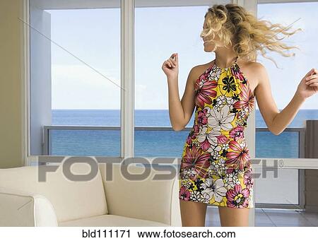Stock Image - Caucasian woman dancing in living room. Fotosearch