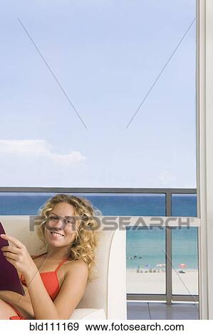 Caucasian woman reading in armchair View Large Photo Image Stock Photo - Caucasian woman reading in armchair. Fotosearch