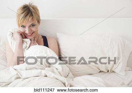 Caucasian woman smiling in bed View Large Photo Image Stock Photo - Caucasian woman smiling in bed. Fotosearch
