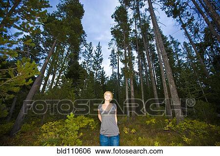 Stock Photograph - Caucasian woman standing in forest. Fotosearch