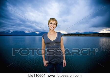 Picture - Caucasian woman standing near lake. Fotosearch