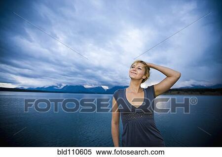 Stock Photography - Caucasian woman standing near lake. Fotosearch