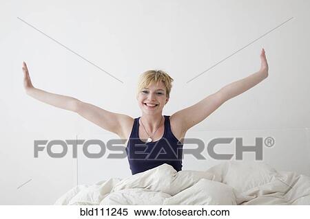 Caucasian woman stretching on bed View Large Photo Image Stock Photography - Caucasian woman stretching on bed. Fotosearch