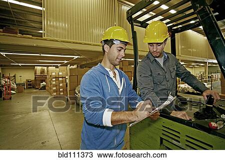 Caucasian workers talking in warehouse View Large Photo Image Stock Image - Caucasian workers talking in warehouse. Fotosearch