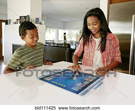 Children playing on computer in table View Large Photo Image Stock Photography - Children playing on computer in table. Fotosearch