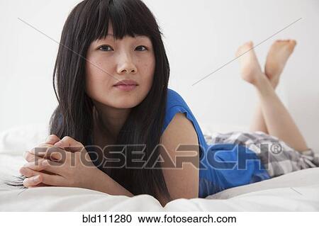 Chinese woman laying on bed View Large Photo Image Stock Image - Chinese woman laying on bed. Fotosearch