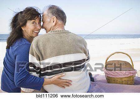 Stock Photograph - Couple having picnic on beach. Fotosearch