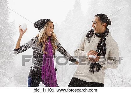 Couple having snowball fight outdoors View Large Photo Image Stock Photography - Couple having snowball fight outdoors. Fotosearch