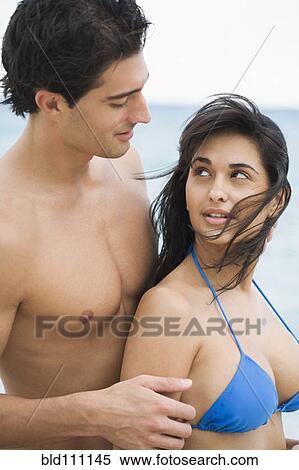 Stock Photography - Couple hugging on beach. Fotosearch