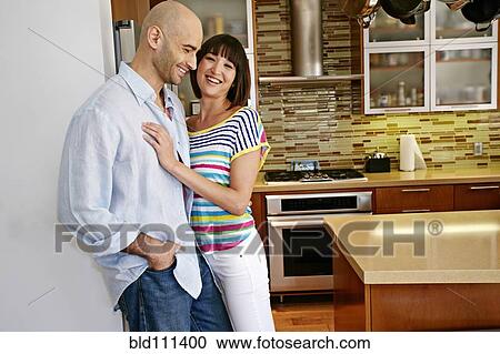 Couple laughing in kitchen View Large Photo Image Stock Image - Couple laughing in kitchen. Fotosearch