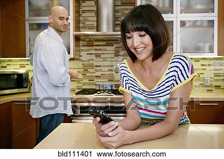 Stock Image - Couple relaxing in kitchen. Fotosearch