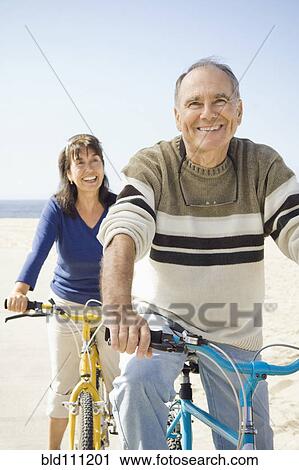 Couple sitting on bicycles on beach View Large Photo Image Stock Image - Couple sitting on bicycles on beach. Fotosearch