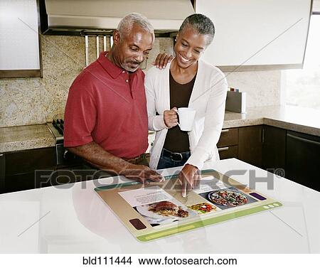 Couple using computer in table View Large Photo Image Picture - Couple using computer in table. Fotosearch