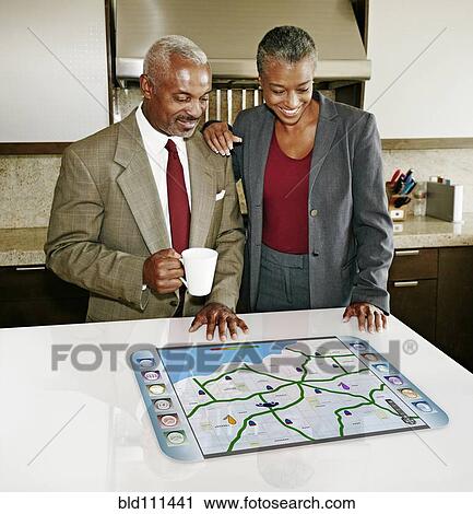 Stock Image - Couple using computer in table. Fotosearch
