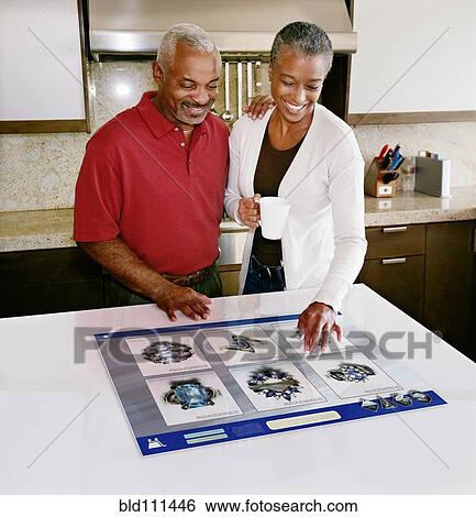 Stock Photograph - Couple using computer in table. Fotosearch