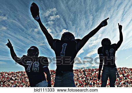 Stock Image - Football players cheering in game. Fotosearch
