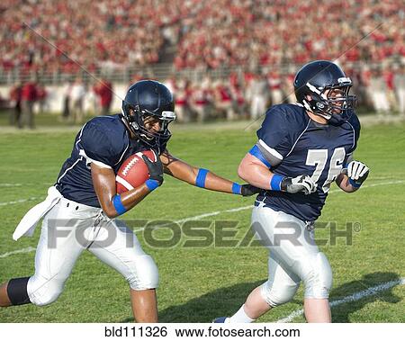Football players passing ball View Large Photo Image Stock Photograph - Football players passing ball. Fotosearch