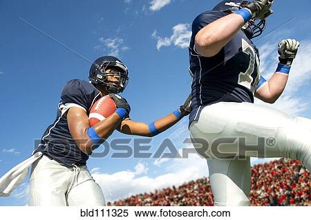 Stock Photography - Football players passing ball. Fotosearch