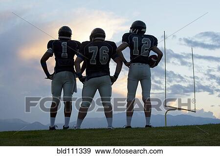 Football players standing on field View Large Photo Image Stock Photo - Football players standing on field. Fotosearch