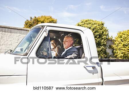 Stock Photo - Hispanic bride and father riding in truck. Fotosearch