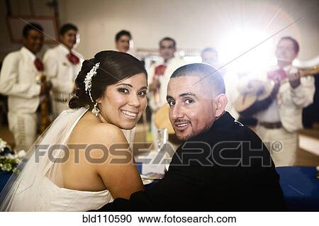 Stock Image - Hispanic bride and groom at wedding reception. Fotosearch
