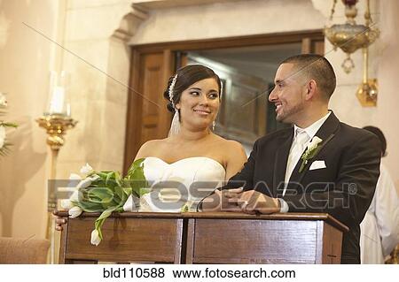 Stock Photo - Hispanic bride and groom in wedding ceremony. Fotosearch