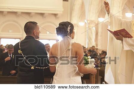 Stock Photo - Hispanic bride and groom in wedding ceremony. Fotosearch