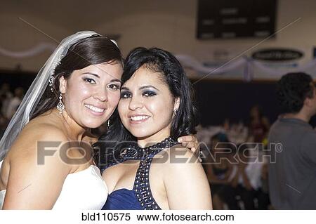 Stock Photography - Hispanic bride hugging friend. Fotosearch