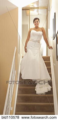 Stock Photo - Hispanic bride standing on staircase. Fotosearch