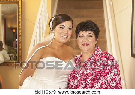 Stock Photo - Hispanic bride standing with mother. Fotosearch
