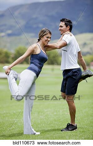 Stock Image - Hispanic couple stretching together. Fotosearch
