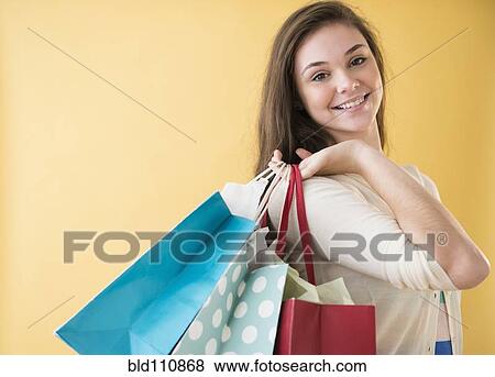 Stock Photo - Hispanic girl carrying shopping bags. Fotosearch