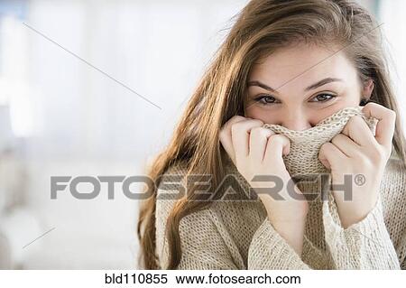 Stock Photography - Hispanic girl covering her face with sweater. Fotosearch