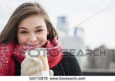 Stock Photo - Hispanic girl drinking coffee in snow. Fotosearch