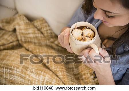 Stock Image - Hispanic girl drinking hot chocolate. Fotosearch