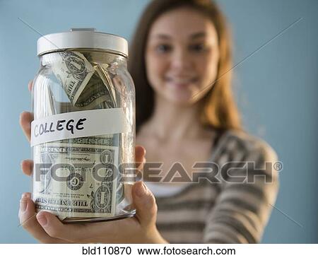 Stock Image - Hispanic girl holding? 'college' savings ja. Fotosearch