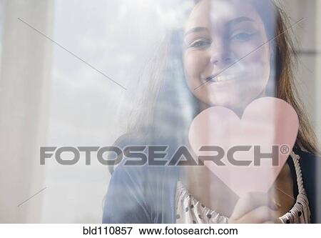 Stock Photo - Hispanic girl holding heart. Fotosearch