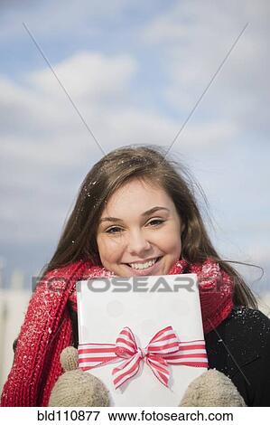 Hispanic girl holding present in snow View Large Photo Image Stock Photo - Hispanic girl holding present in snow. Fotosearch