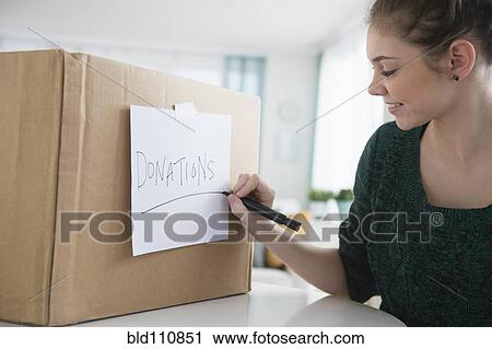 Stock Image - Hispanic girl marking? 'donations' bo. Fotosearch
