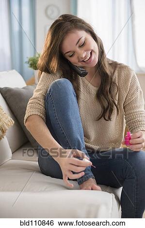 Stock Photograph - Hispanic girl painting her toenails. Fotosearch