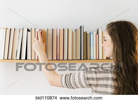 Hispanic girl selecting book from shelf View Large Photo Image Picture - Hispanic girl selecting book from shelf. Fotosearch