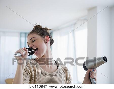Stock Photo - Hispanic girl singing into hairbrush. Fotosearch