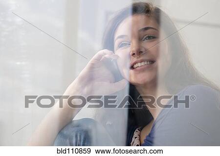 Stock Photo - Hispanic girl talking on cell phone. Fotosearch