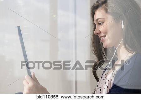Stock Photo - Hispanic girl using tablet computer. Fotosearch