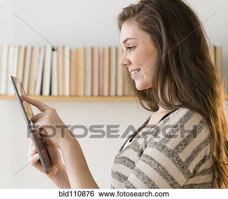 Stock Photograph - Hispanic girl using tablet computer. Fotosearch